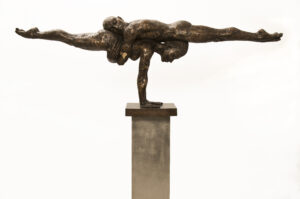 A sculpture of two acrobats lying horizontal holding each other up.