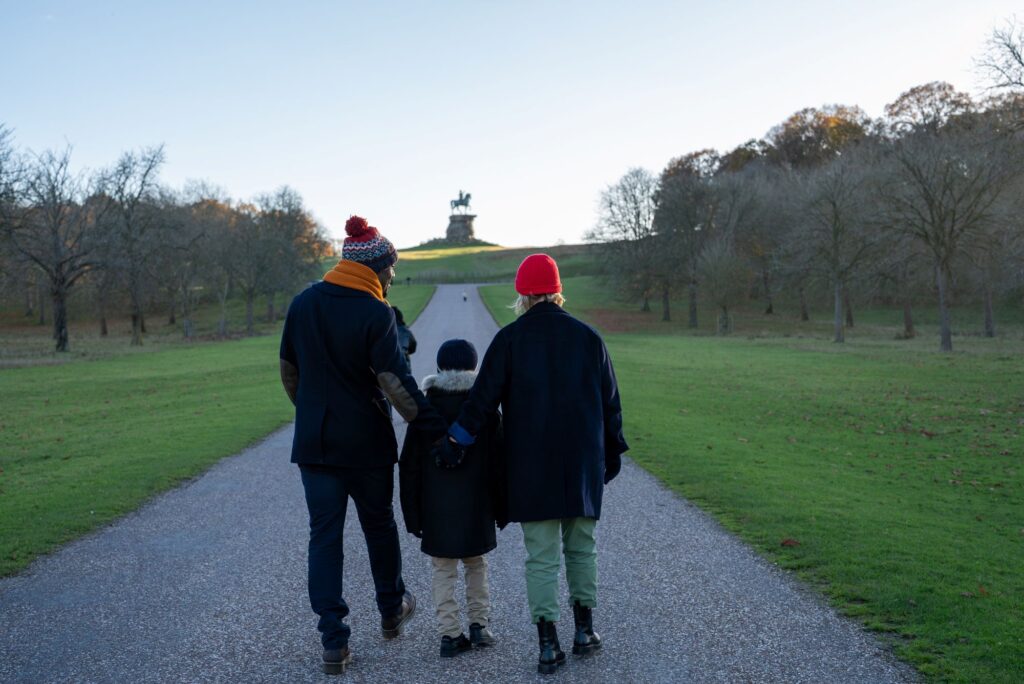 Three people walking towards the Copper Horse on the Long Walk.