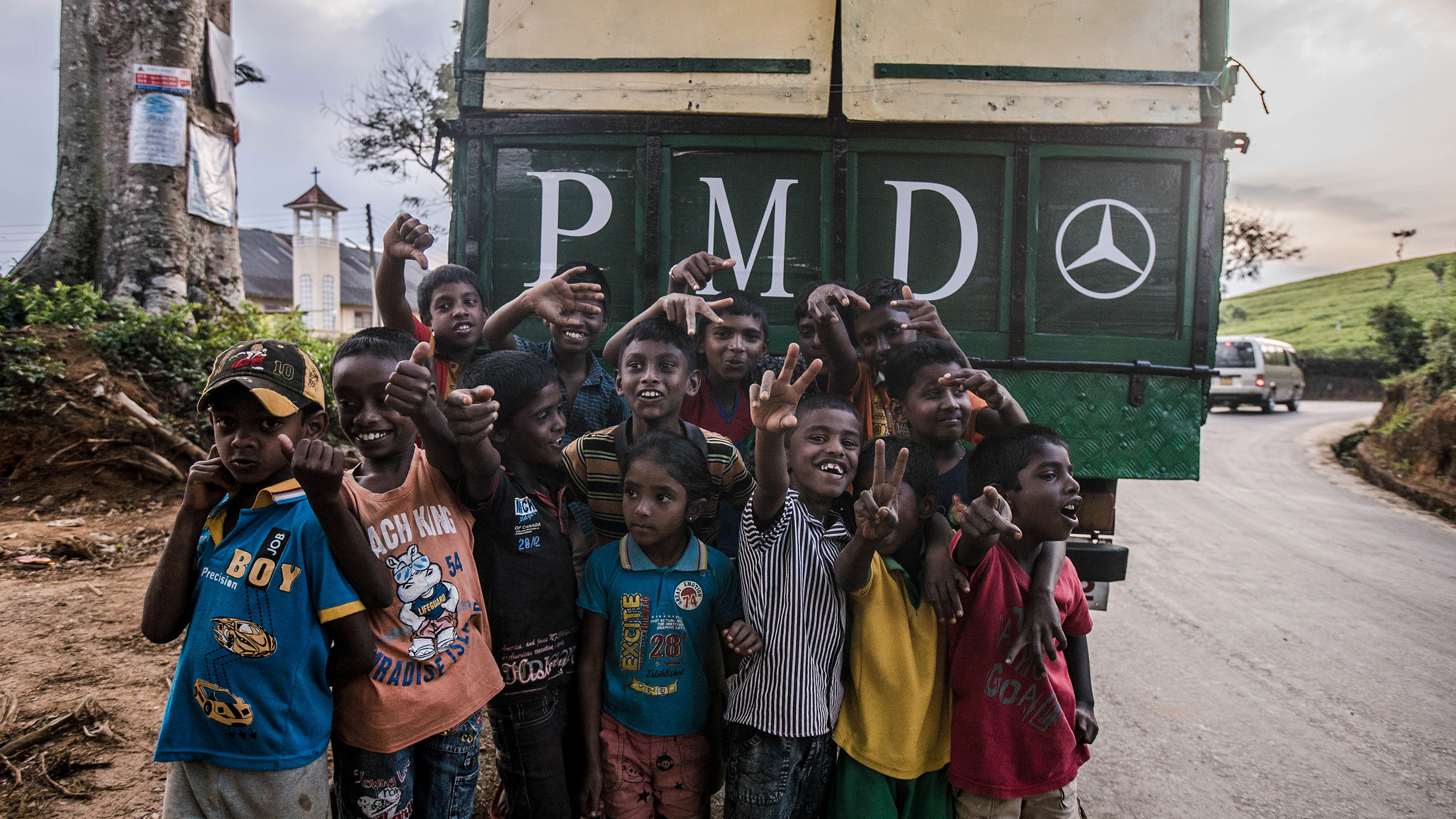 A group of children standing in front of a tea lorry.