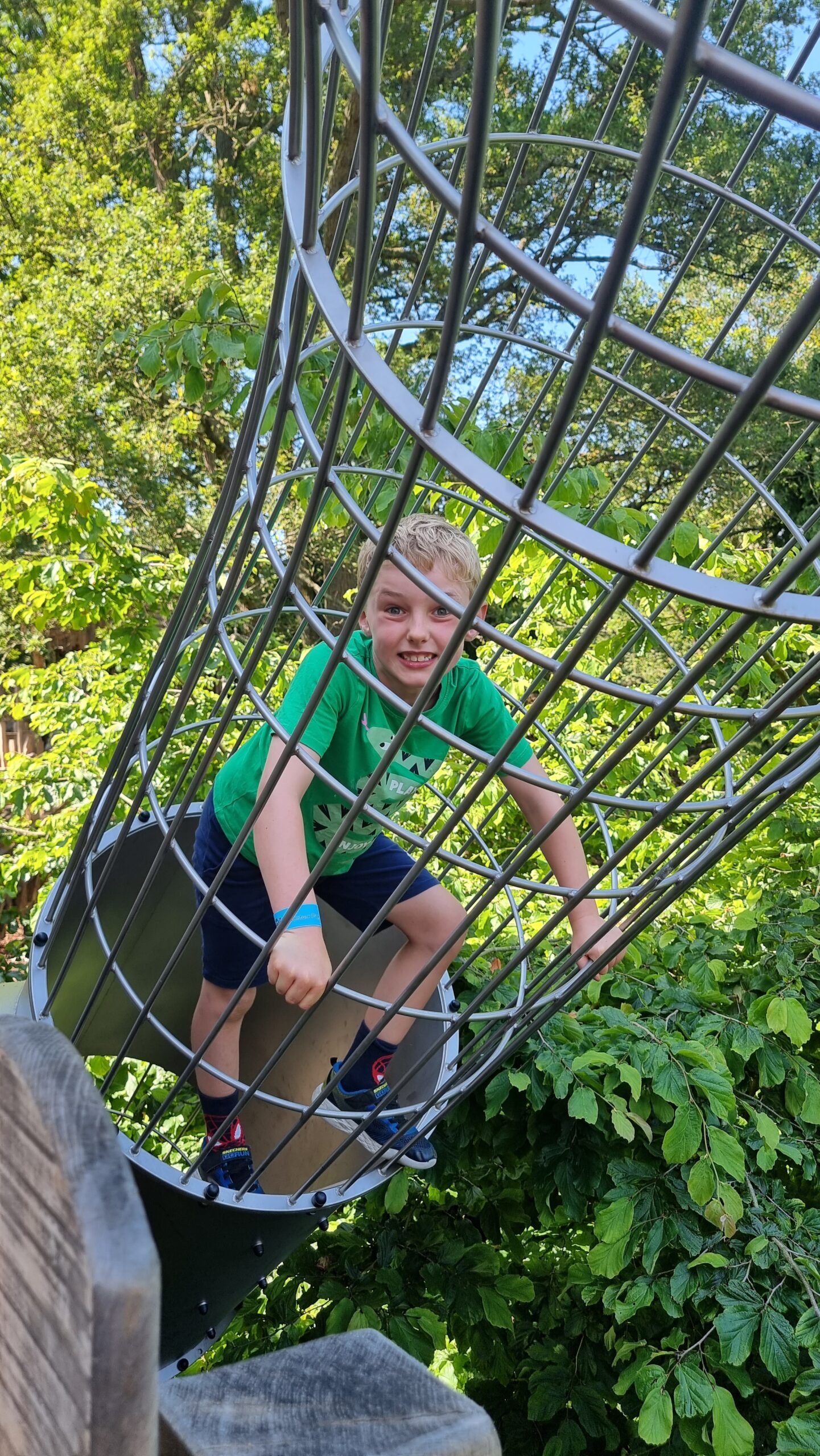 Young child climbing through a steel net.