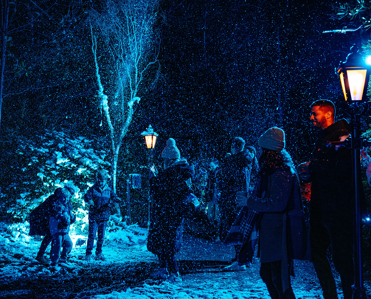 Adults and children having fun in fake snow at Windsor Great Park Illuminated.