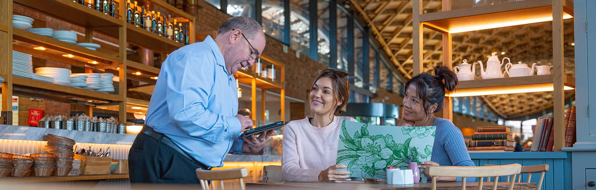 Two people being served by service staff at The Savill Garden Kitchen.
