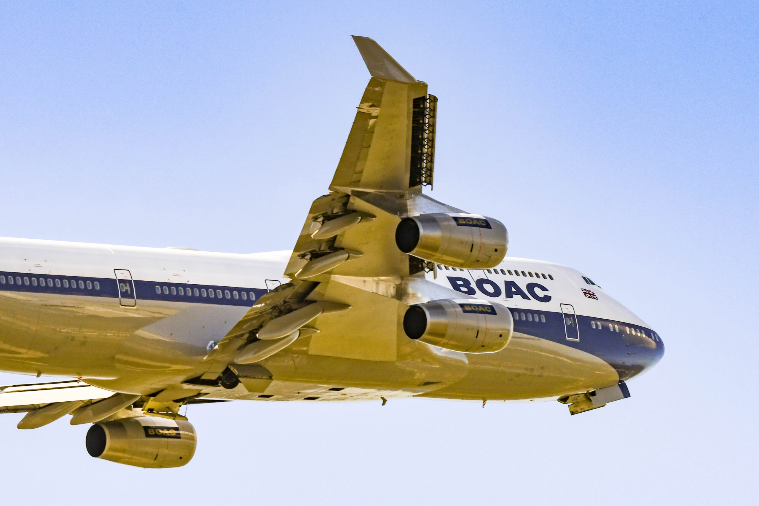 A blue and white plane in flight, with BOAC (British Overseas Airways Corporation) written on the side.