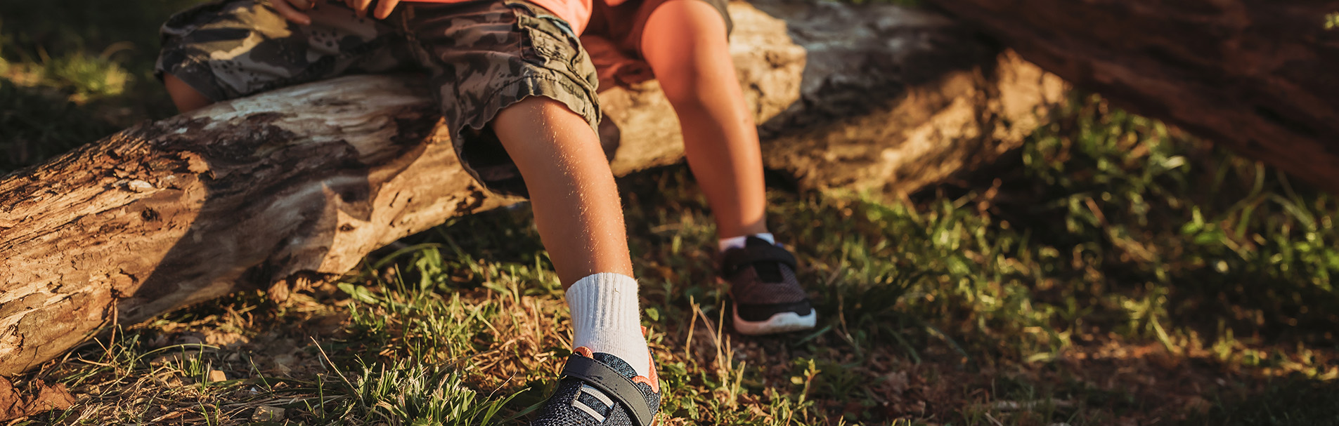 Children sitting on a log.